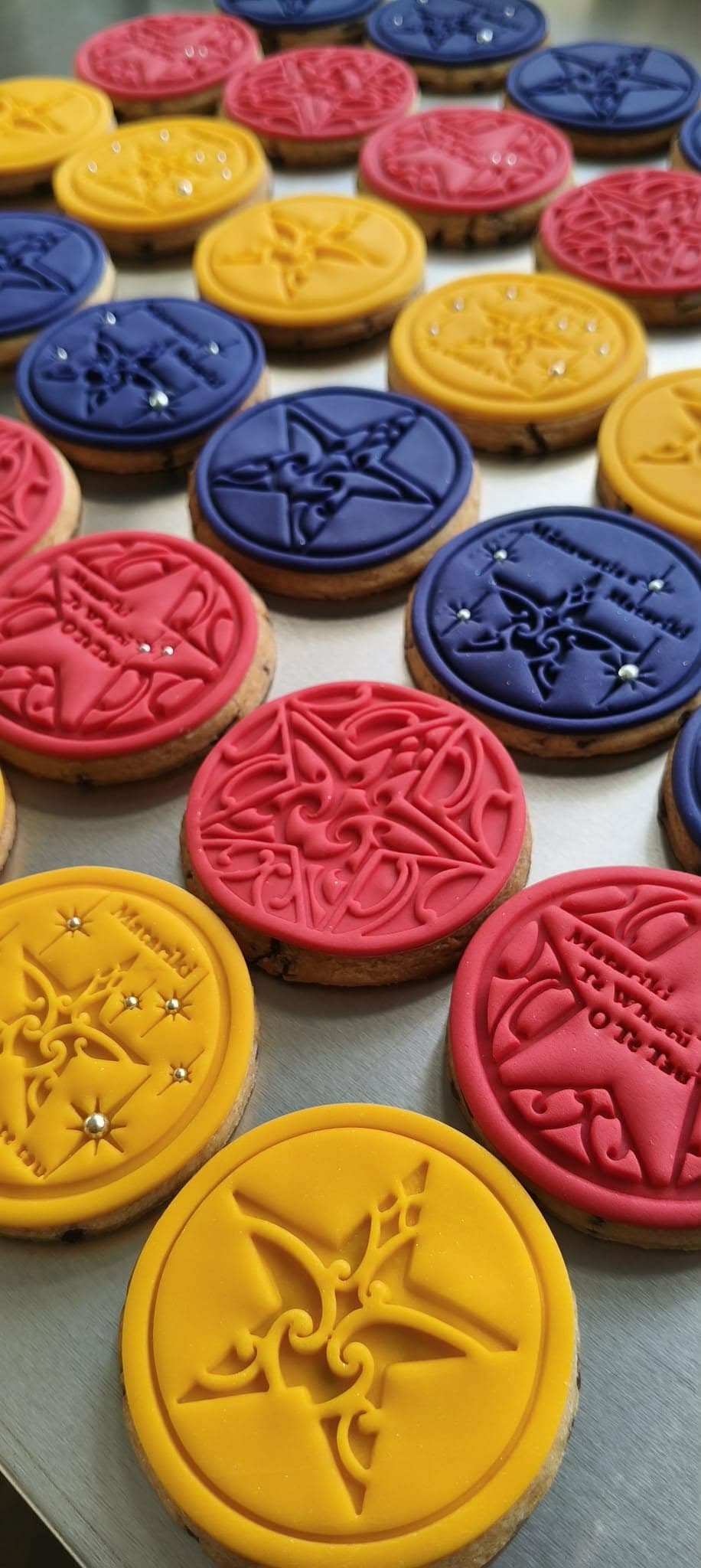 Matariki collection cookies in pink, blue, and yellow on a tray
